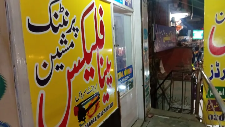 Digital World's yellow panaflex shop board at night